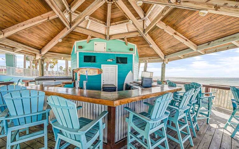 outdoor tiki bar with aqua colored chairs at beachcomber beachfront hotel panama city beach