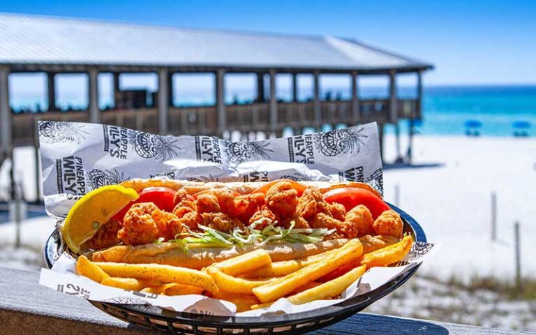 po boy on tray with sides with pier and beach background at pineapple willys panama city beach