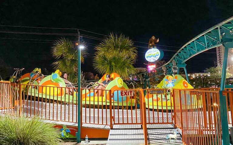 riders on colorful spinning ride at night at swampy jacks wongo adventure panama city beach