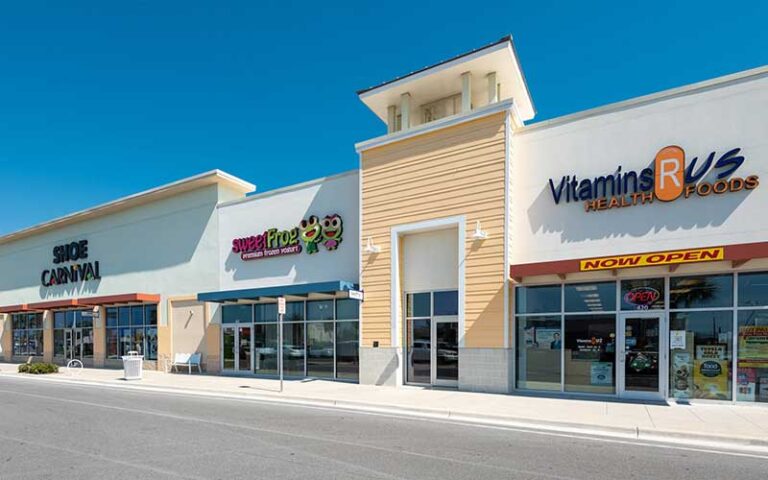 row of store fronts with parking at pier park north panama city beach