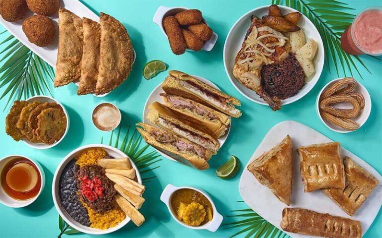 spread of cuban entrees on blue table at mi apa latin cafe gainesville