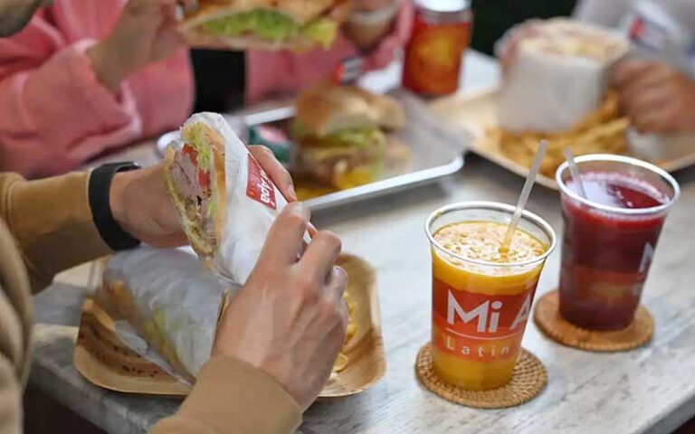 tables with drinks and diner eating sandwich at mi apa latin cafe gainesville