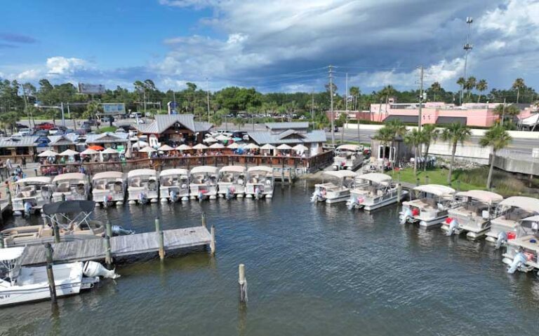 waterfront marina with rows of pontoon boats at adventures at sea panama city beach