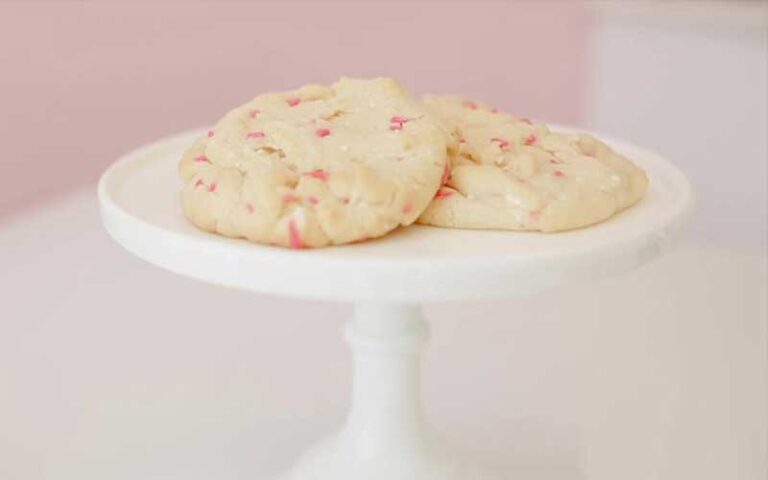 white cookies with pink flecks on cake stand at crumbl gainesville