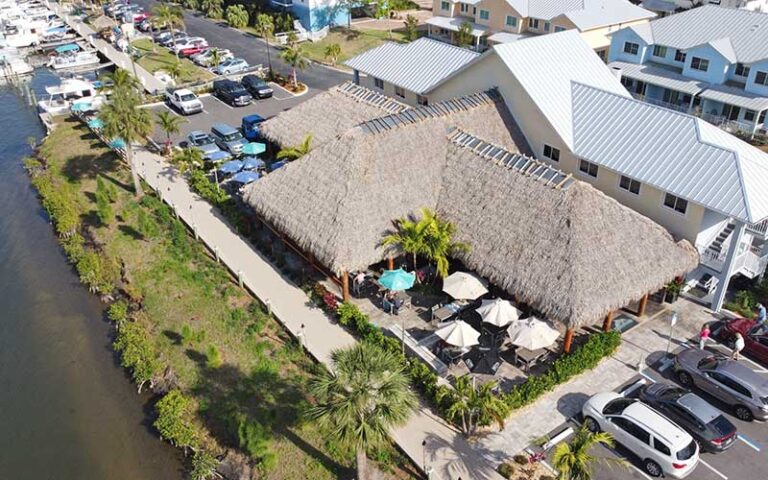 aerial view of restaurant with tiki hut thatch at dolphins waterfront bar grill at cape crossing merritt island