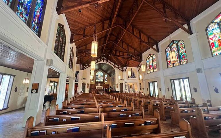 angled church interior with wood pews and stained glass at st pauls episcopal church key west