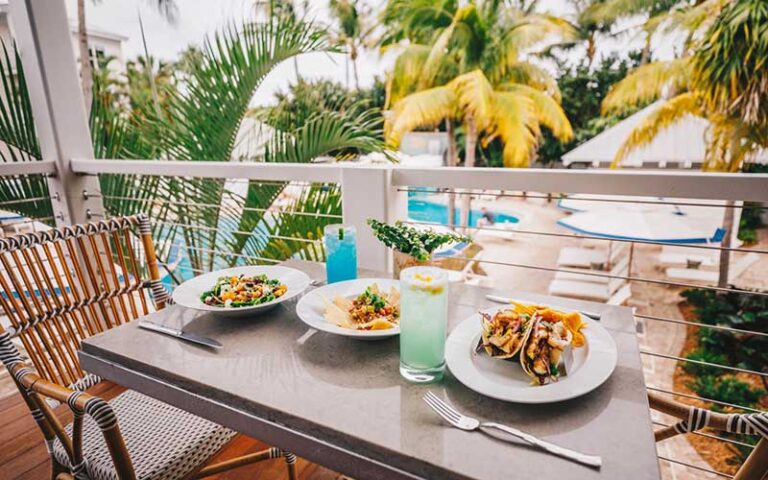 balcony dining with entrees and palms at margaritaville beach house key west