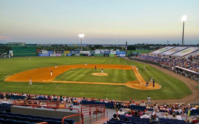 baseball field with players and crowd at twilight at usssa space coast complex melbourne