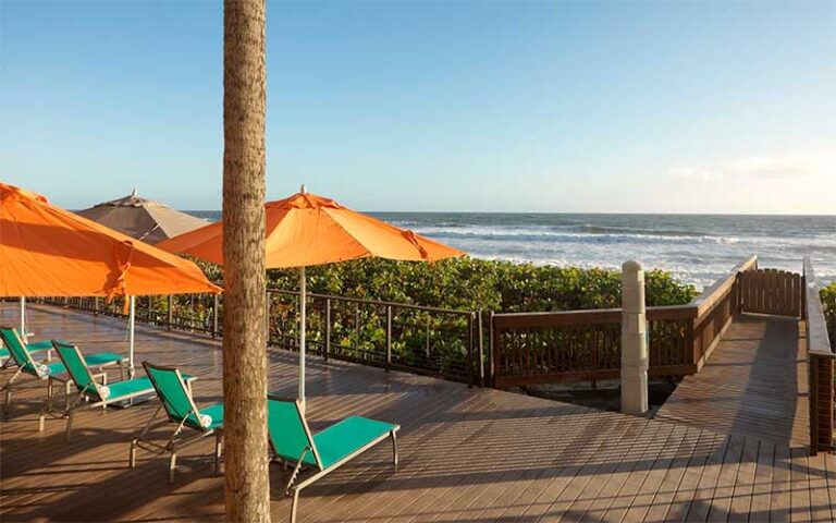 beachside deck with loungers and shades at doubletree suites melbourne beach oceanfront