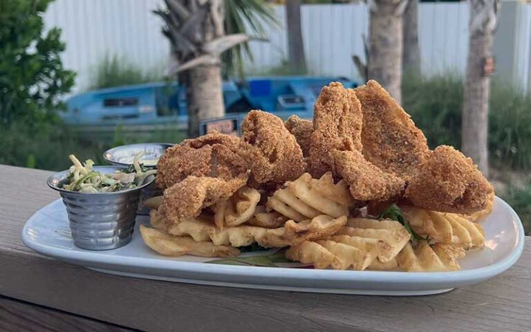 catfish and waffle fries entree on outdoor patio table at cocoa beach fish camp