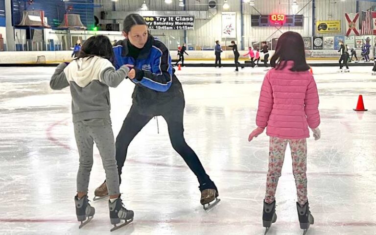 coach teaching figure skating to girls on rink at space coast iceplex rockledge