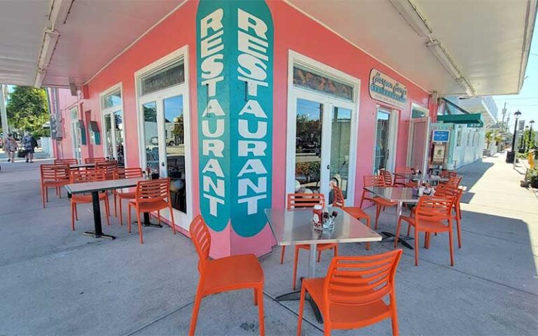 corner of sidewalk with dining tables and chairs at harpoon harrys key west