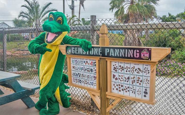 costumed gator pointing at gem mining sign at gator n golf cape canaveral