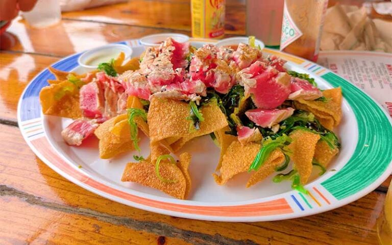 crab nachos with hot sauce on table at hogfish bar grill key west