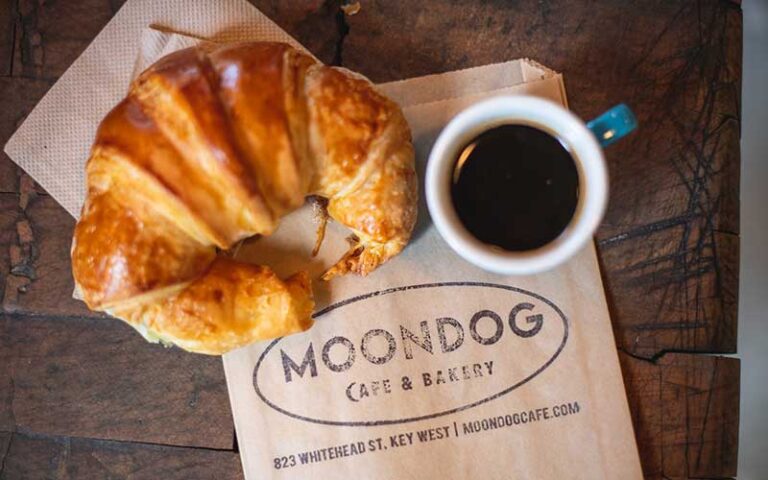 croissant and coffee with branded napkin at moondog cafe key west