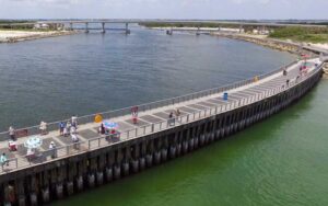 curving fishing pier with inlet channel and beaches at sebastian inlet state park melbourne beach