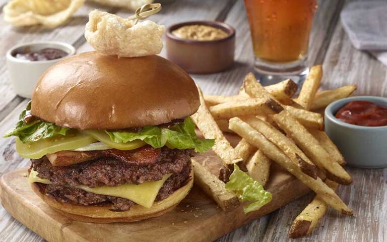 double burger with sides and beer at rising tide tap table port canaveral