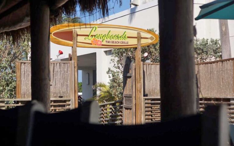 fence gateway with logo sign at longboards tiki beach grille cocoa beach