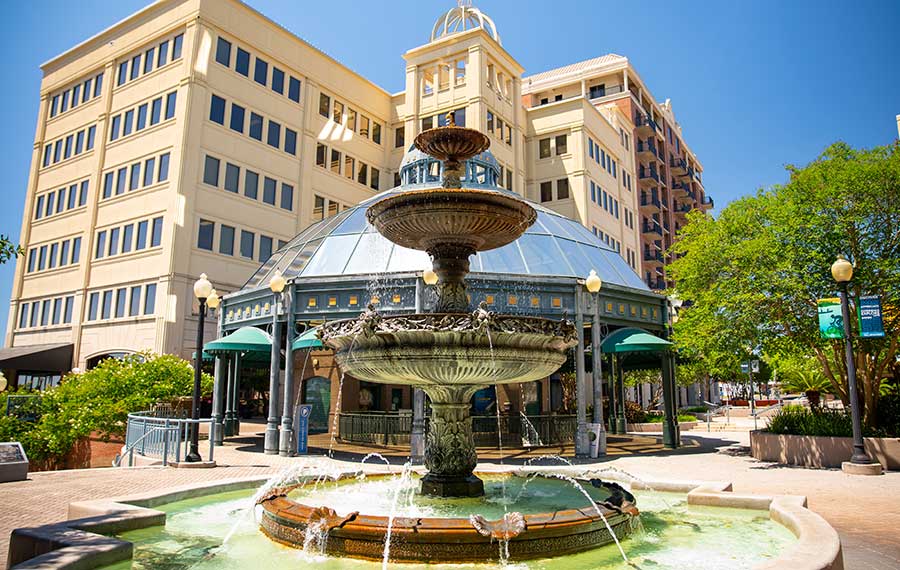 fountain in kleman plaza with glass dome entrance behind at downtown tallahassee