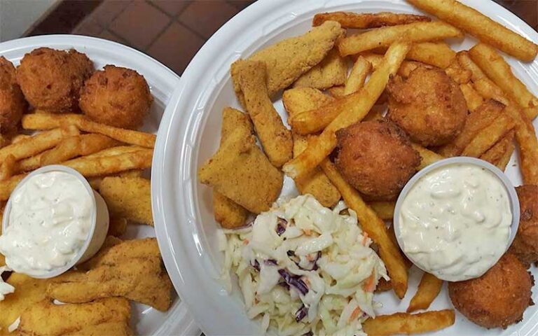 fried fish and sides on plates at the old fish house bar grill grant valkaria