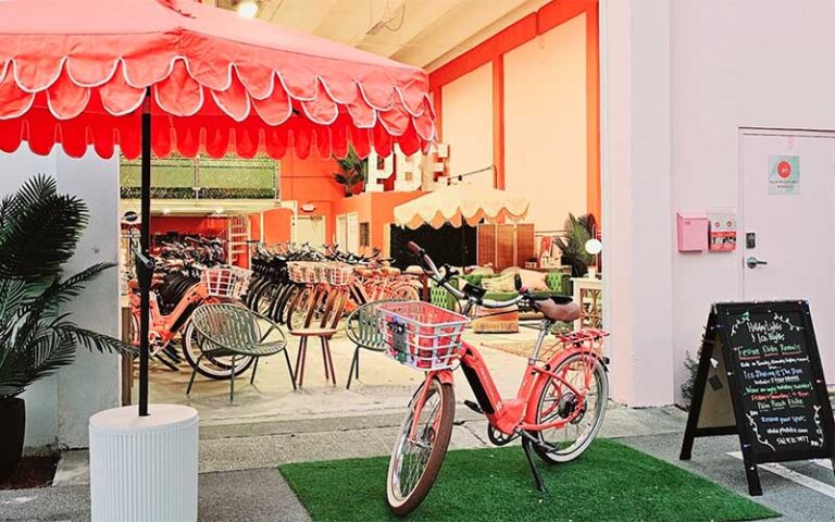 garage style shop with pink umbrella and ebike at palm beach ebike rentals west