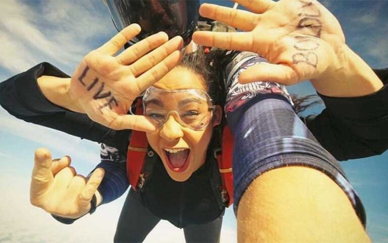 girl in tandem dive with live boldly written on hands at skydiving space center titusville