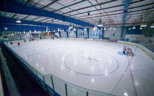 large ice rink with hockey goal and skaters at space coast iceplex rockledge