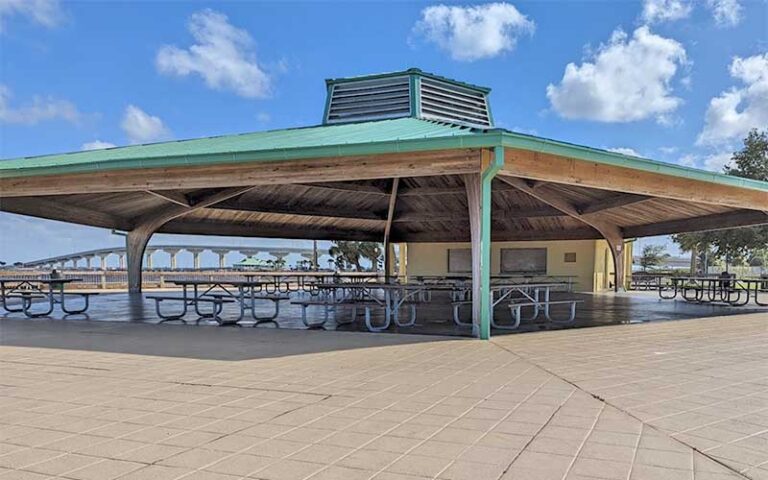 large pavilion with tables in plaza with bridge in background at sand point park titusville