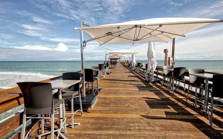 long dock over beach with seating and shades at westgate cocoa beach pier