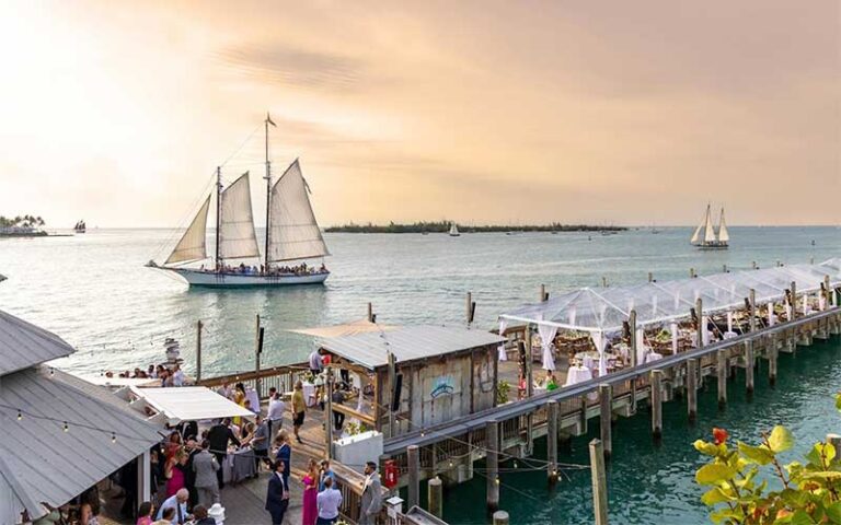 long pier with wedding tents and sailboat on ocean at ocean key resort spa key west