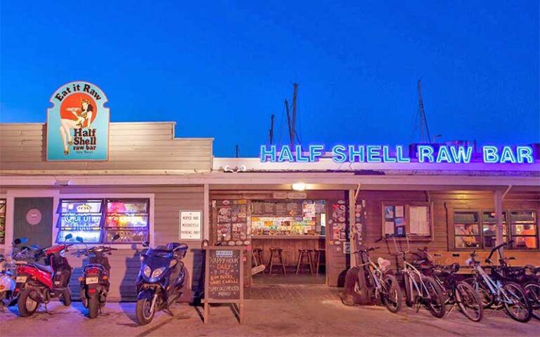 night exterior of restaurant with bikes and mopeds at half shell raw bar key west