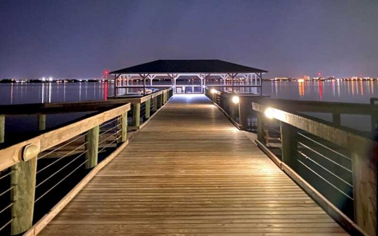 night view from shore of pier with covered dock area and lights at melbourne beach pier space coast