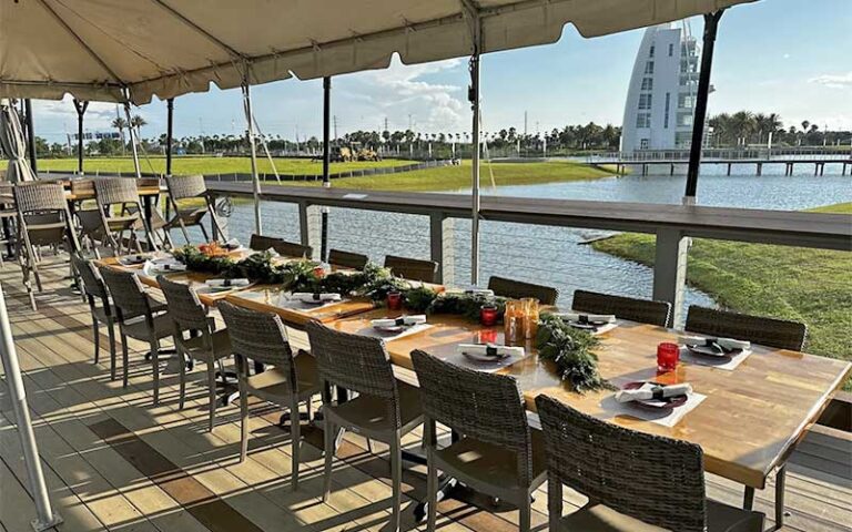 outdoor patio with covered seating and view of tower at rising tide tap table port canaveral