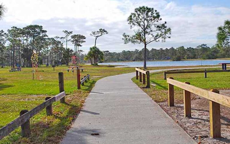 park area with paved pathway and lake at wickham park melbourne