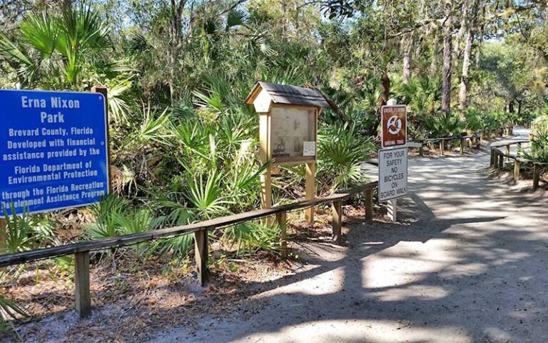 path through woods with signs and fence at erna nixon park west melbourne