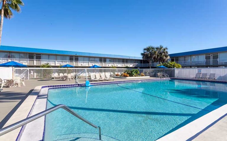 pool area surrounded by two story hotel buildings at days inn by wyndham titusville kennedy space center