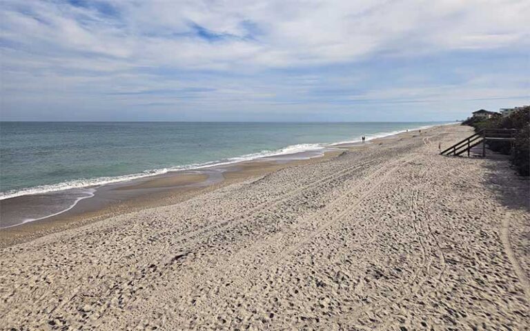 pristine beach with dune and cloudy sky at pelican beach park satellite beach