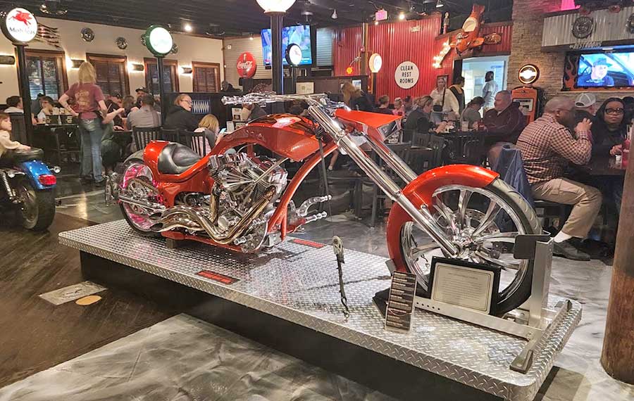 restaurant dining room with crowded tables and red custom motorcycle exhibited at the wicked wheel panama city beach