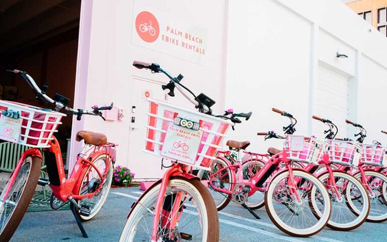 rows of red bikes outside storefront at palm beach ebike rentals west