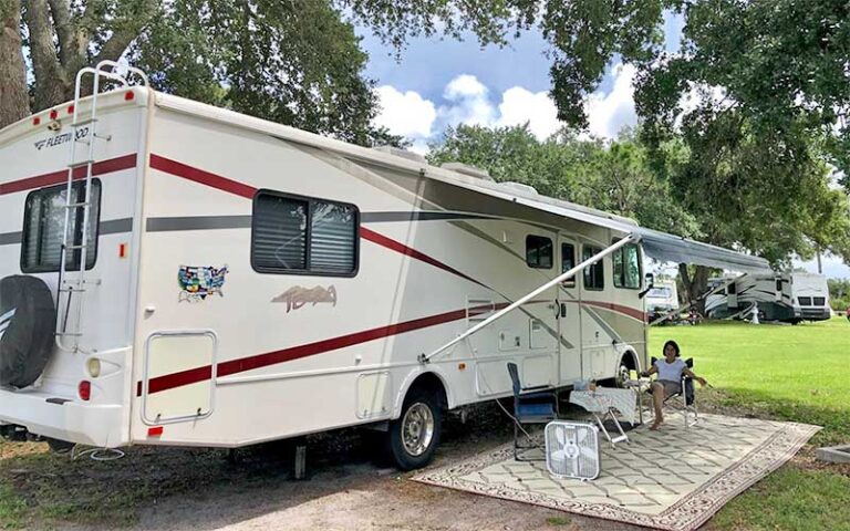 rv in park with camper seated under awning at wickham park melbourne