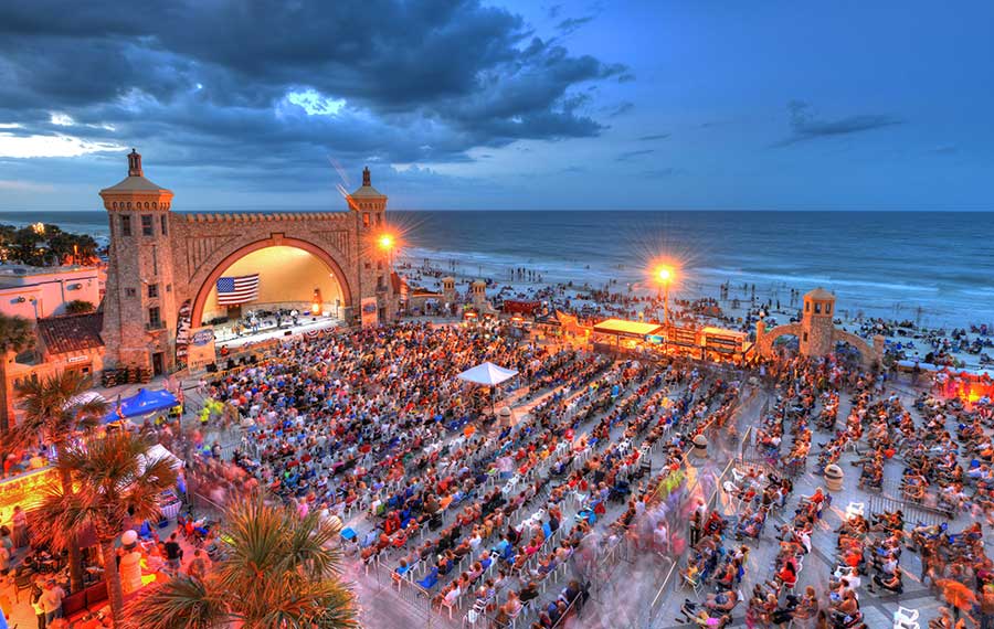 seated crowd at night concert with beach twilight background at daytona beach bandshell