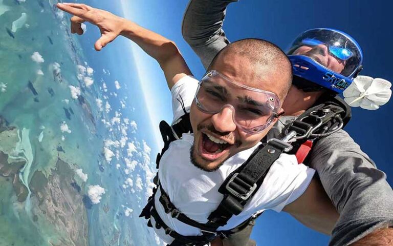 skydiver smiling with tandem in cloudy sky at skydive key west