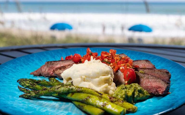 steak with sides entree on blue plate at longboards tiki beach grille cocoa beach