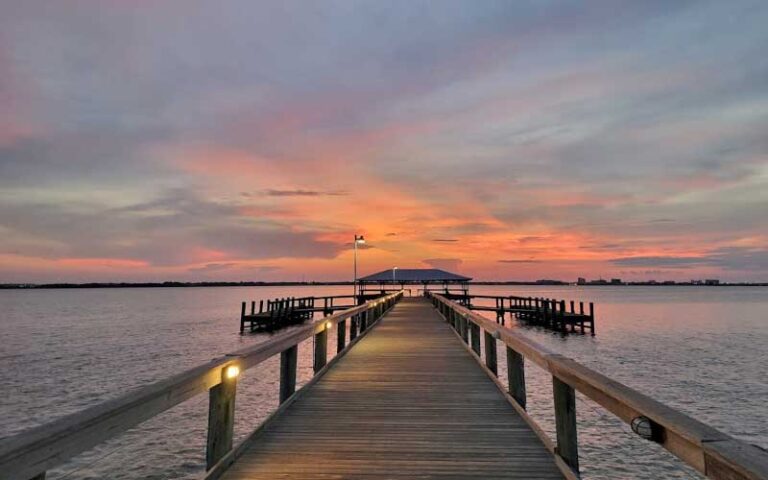 twilight view of lighted pier with purple cloudy sky at melbourne beach pier space coast