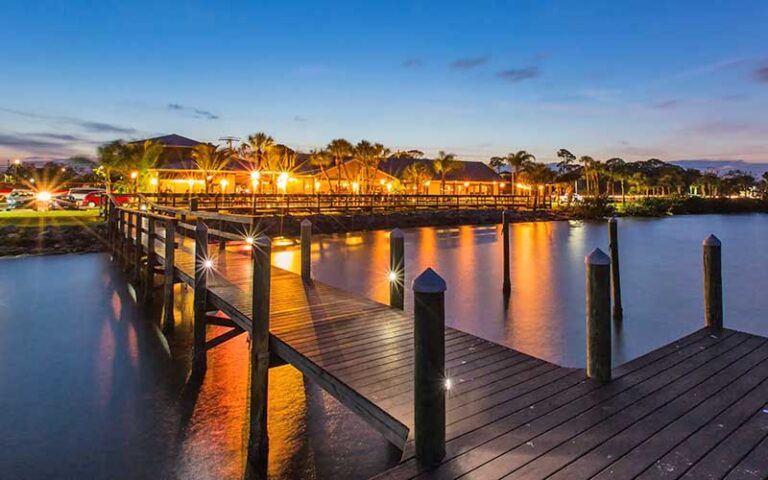 twilight view of lighted restaurant from dock at river rocks rockledge