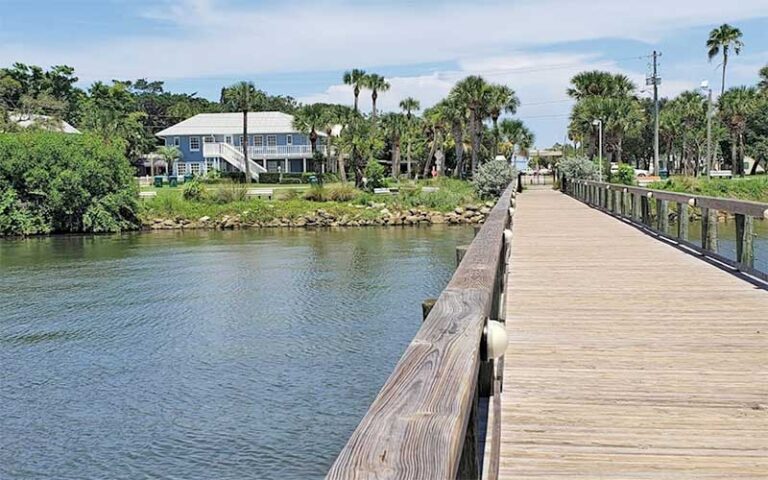 view along dock of bank with house and park at melbourne beach pier space coast