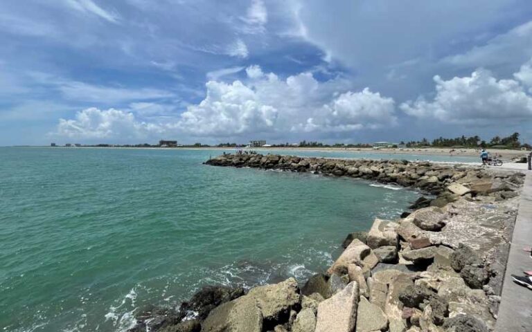 view from jetty of coast with cloudy sky at sebastian inlet state park melbourne beach