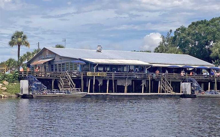 view from river of exterior restaurant and dock at lone cabbage fish camp cocoa