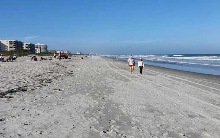 wide beach with walkers and distant condos at lori wilson park cocoa beach