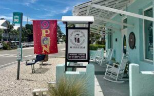 aqua colored house along street with signs at anna maria island historical society